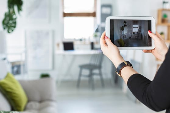Photo showing someone using a tablet to video items in their home.