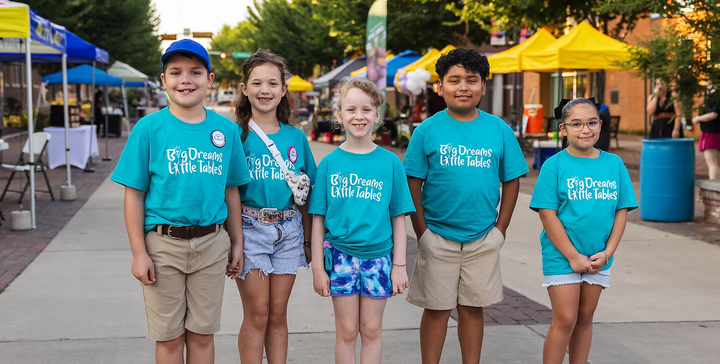 Young entrepreneurs pose for a photo at the farmers market.
