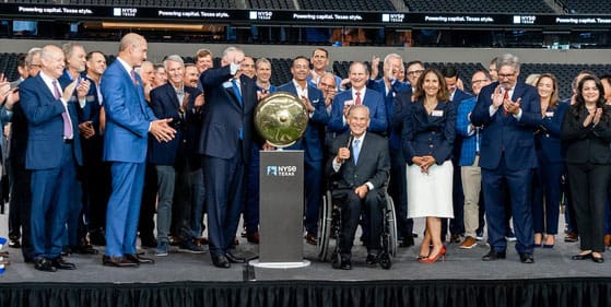A group of people ringing the bell at a stock exchange.