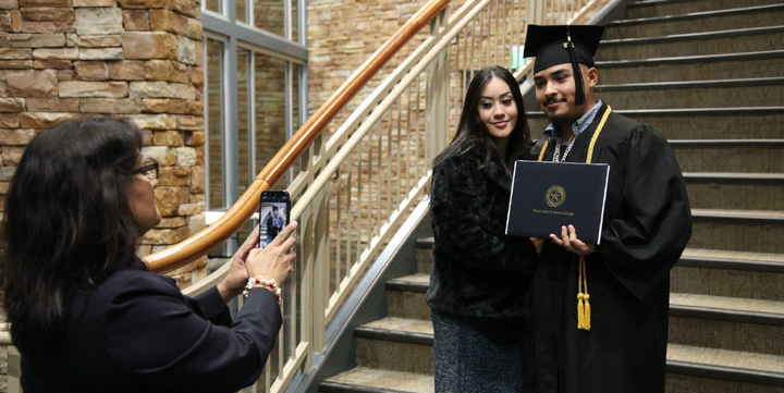 Photo of a recent graduate holding a diploma.